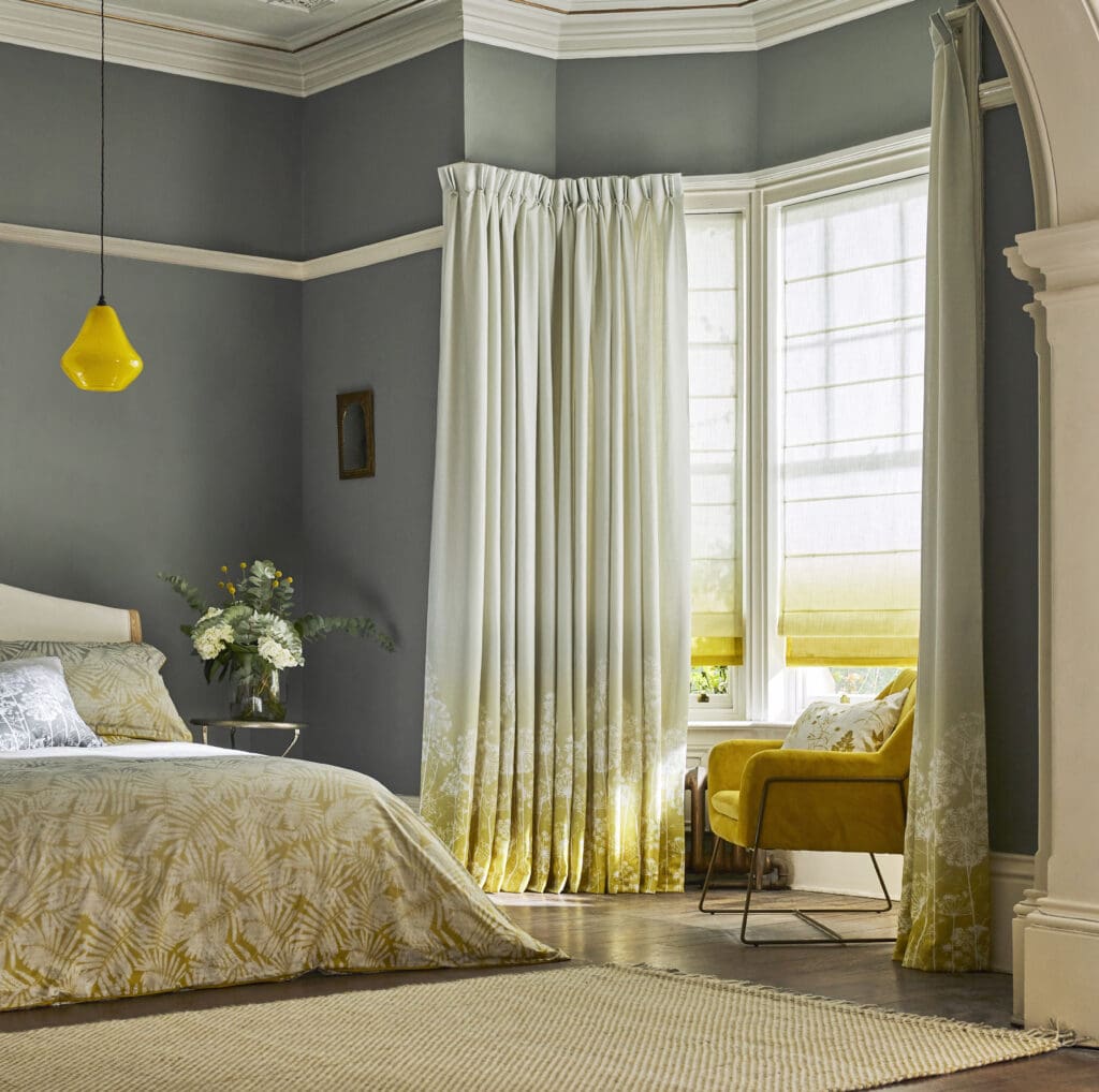 Clarissa Hulse Collection in yellow ochre with matching roman blinds in a bedroom in a bay window