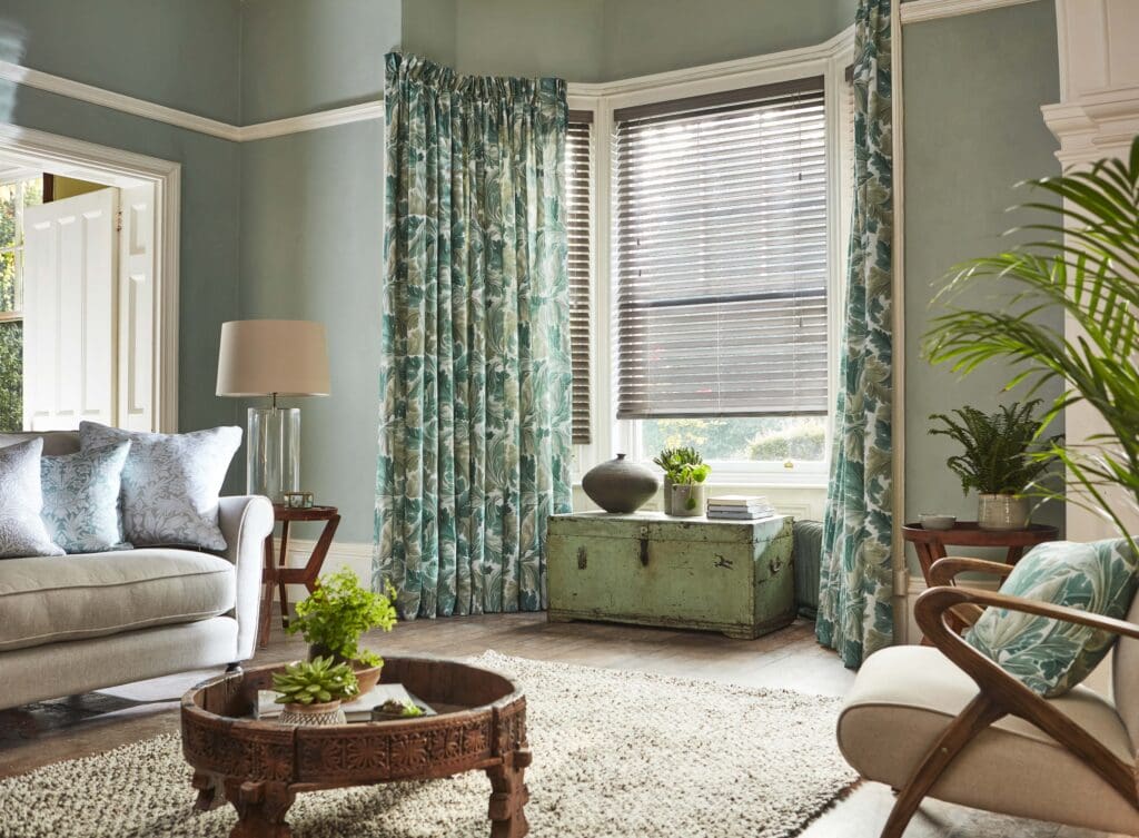 William Morris Acathus Curtains & Metropolitan Classic Oak Wooden Blind 50 mm Slat in a green living room in a bay window